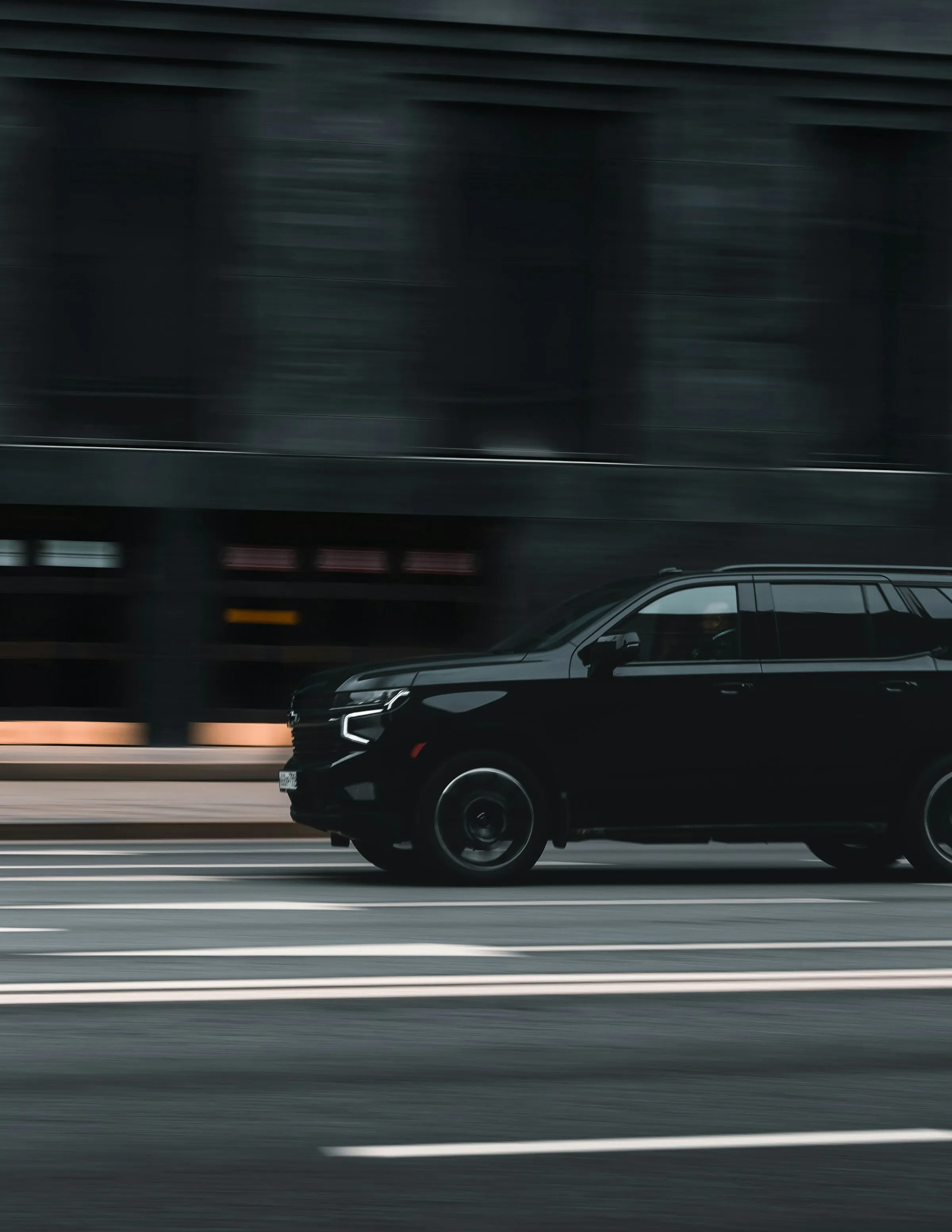 Black Chevrolet Suburban in motion through a city