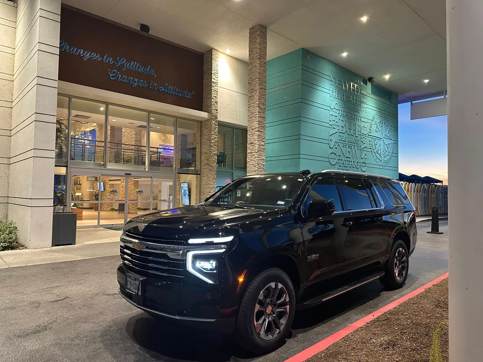 B N Lux Ride Chevrolet Suburban at a hotel entrance at dusk