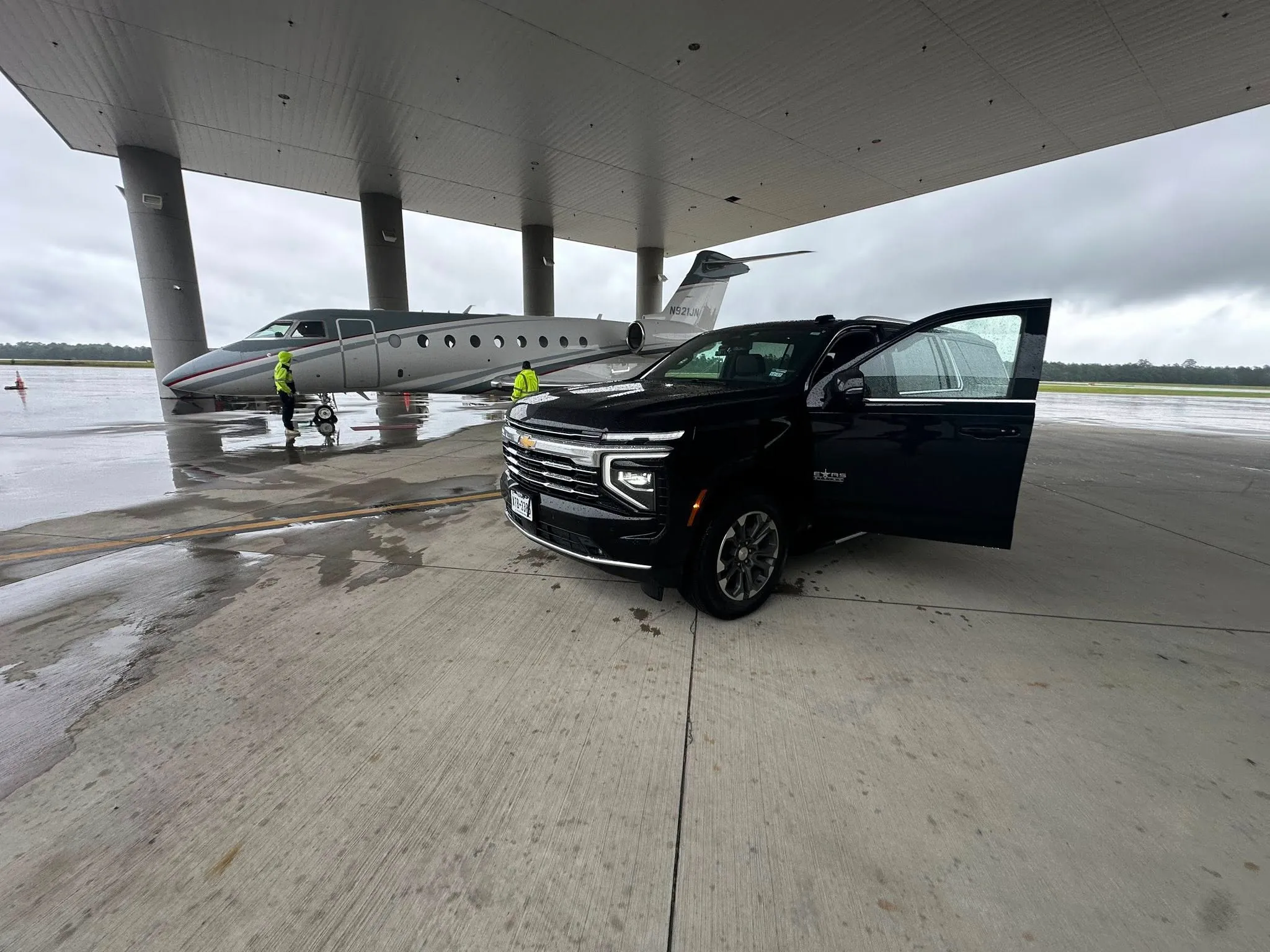 Chevrolet Suburban door open beside a private jet